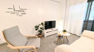 een woonkamer met een bank en een tv bij Rincón del Atlántico in Rota