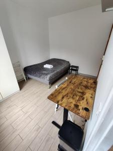 Habitación con cama y mesa de madera. en Studio Tour Eiffel, en Aulnay-sous-Bois
