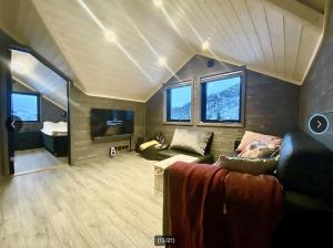 un soggiorno con un divano e una TV di Fjellhytte med ski inn-ut a Torvetjørn
