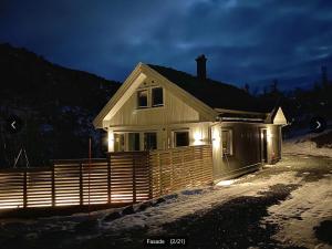 una casa con le luci sulla neve di Fjellhytte med ski inn-ut a Torvetjørn