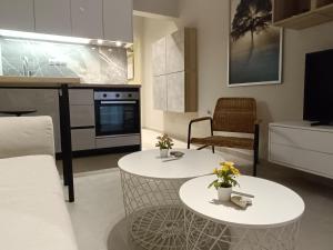 a living room with two tables and a kitchen at Ioana Apartment Siviri in Siviri