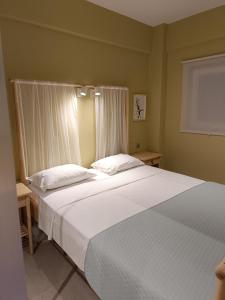 a bedroom with a large white bed and a window at Ioana Apartment Siviri in Siviri