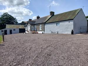 a large white building with a large gravel driveway at Bramble Cottage in Dungannon