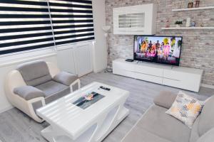 a living room with a couch and a tv at Apartman Marina in Foča