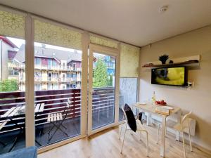 a living room with a table and a large window at Good Vibes :) in Juodkrantė