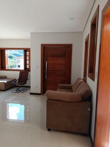 a living room with a couch and a wooden door at Sua casa em nossa casa in Diamantina