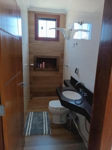 a bathroom with a toilet and a sink and a window at Sua casa em nossa casa in Diamantina +34 photos
