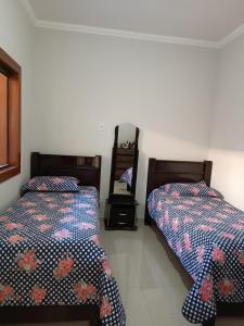 two beds sitting next to each other in a bedroom at Sua casa em nossa casa in Diamantina