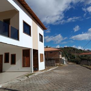 a white house with a cobblestone street at Sua casa em nossa casa in Diamantina