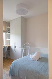 a white bedroom with a bed and a desk at Trójmiejski przystanek in Sopot