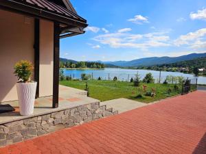 eine Vase an der Seite eines Gebäudes mit Blick auf einen See in der Unterkunft Kuća za odmor Sabljaci in Ogulin