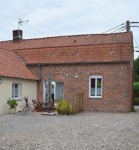 a brick house with a table and chairs in front of it at La maison d'Arthur et Armelène in Rely