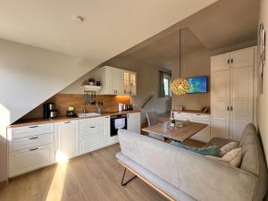 a living room with a couch and a kitchen at Ferienanlage Eldena Ferienwohnung 12 in Lobbe +32 photos