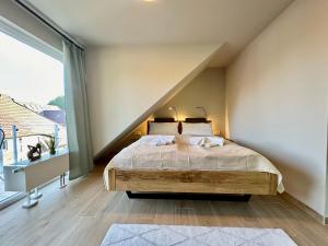 a bedroom with a bed and a large window at Ferienanlage Eldena Ferienwohnung 12 in Lobbe