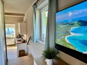 a living room with a flat screen tv hanging on a wall at Ferienanlage Eldena Ferienwohnung 12 in Lobbe