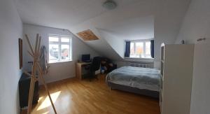 Un dormitorio con una cama y un escritorio y dos ventanas. en Reykjavik Condo, en Reikiavik