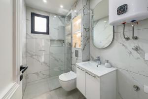 a white bathroom with a toilet and a sink at North Apartments in Bijelo Polje +34 photos