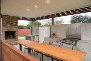 an outdoor kitchen with a wooden table and a grill at Motel Meneres in Corowa