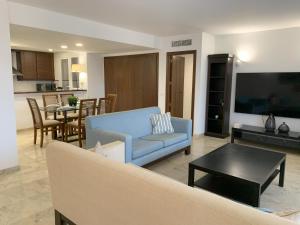 a living room with a blue couch and a table at CC8 by ZANIS in Torrevieja