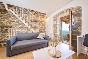 a living room with a couch and a brick wall at Casa Minalu in Marušići