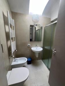 a bathroom with a toilet and a sink and a mirror at Il Borgo Apartments in Vieste +10 photos