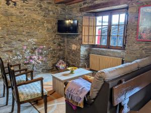 a living room with a couch and a stone wall at O Val de Vilaboa in Bóveda