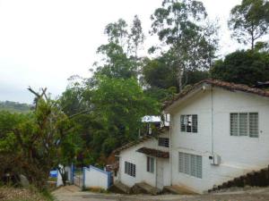 a small white house with trees in the background at Descanso en el Campo in Cali