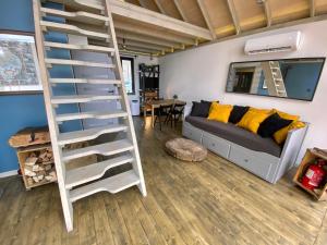 a living room with a ladder and a couch at Szklana Stodoła in Przywidz