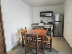 a kitchen with a wooden table and a refrigerator at Departamento Caracol in Puerto Vallarta
