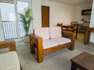 a living room with a white chair and a table at Departamento Caracol in Puerto Vallarta