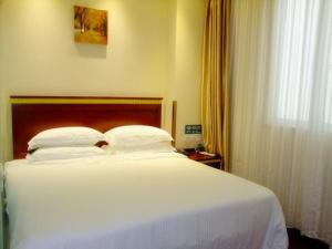 a large white bed in a room with a window at GreenTree Inn Jiangxi Yingtan Jiaotong Road Central Square Business Hotel in Yingtan