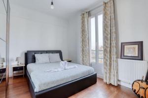a bedroom with a bed and a large window at Superbe T3 très proche Gare Sartrouville in Sartrouville