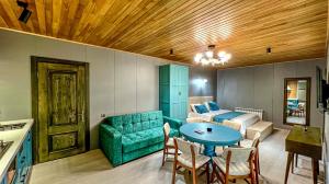 ein Wohnzimmer mit einer grünen Couch und einem Tisch in der Unterkunft Qafqaz Resort Greenway in Qəbələ