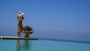 a woman standing on the edge of a swimming pool at Villa La Falaise in Oualidia