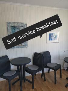 a table and chairs with a sign that reads self service breakfast at Vertshuset Fannarheimr - Bed &Breakfast in Fannrem