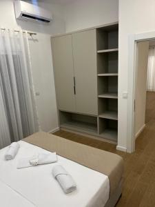 une chambre blanche avec un lit et un placard dans l'établissement Sunny apartments, à Ulcinj 8 autres photos
