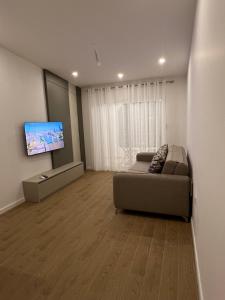 un salon avec un canapé et une télévision à écran plat dans l'établissement Sunny apartments, à Ulcinj