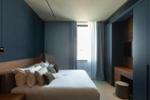 a bedroom with a large bed with blue walls at Palazzo Giusti Lecce - Exclusive Boutique hotel in Lecce