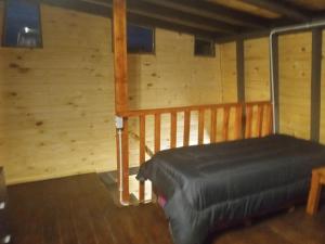 ein Zimmer mit einem Bett in einer Holzhütte in der Unterkunft Cabaña Trapecio in San Carlos de Bariloche