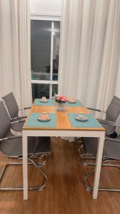 a table with chairs and a table with a blue table at Lindo apto na Enseada - Guarujá - 8 min da praia in Guarujá