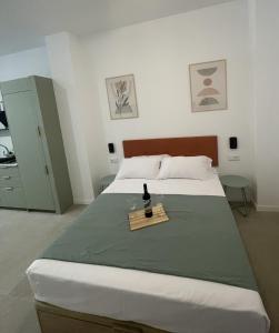 a bedroom with a bed with a bottle of wine on it at Galdós Flats by Vivo GC in Valencia