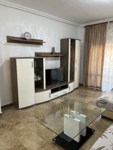 a living room with a tv and a glass table at Titanic in Cazorla