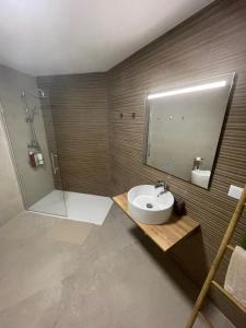 a bathroom with a sink and a shower and a mirror at Galdós Flats by Vivo GC in Valencia
