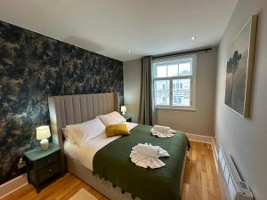 a bedroom with a bed with two towels on it at Brand New Flat in Central London in London