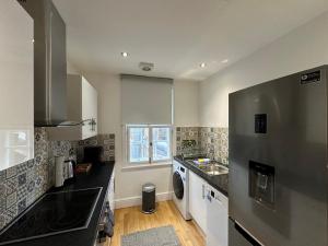 a kitchen with a refrigerator and a sink at Brand New Flat in Central London in London
