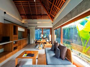 a living room with a couch and a table at The Santai by LifestyleRetreats in Canggu