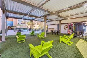 acovered patio with green chairs and tables and tables at Best Western Orlando Gateway Hotel in Orlando