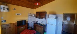 a kitchen with a white refrigerator and a sink at Ruta 20 HOUSE Quines in Quines