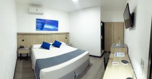 una camera d'albergo con un letto e una TV di Hotel Mar Azul a Manta