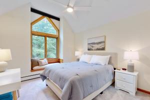 a white bedroom with a bed and a window at Loon Mountain Condo in Lincoln